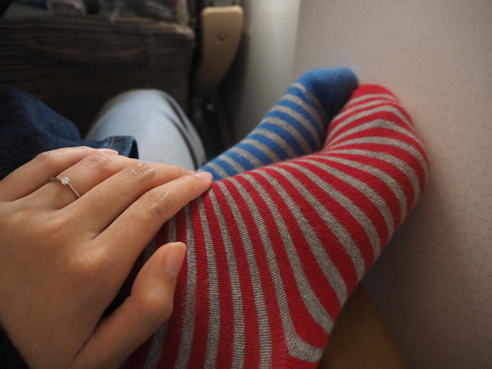 A woman wearing mismatched slippers on a plane.