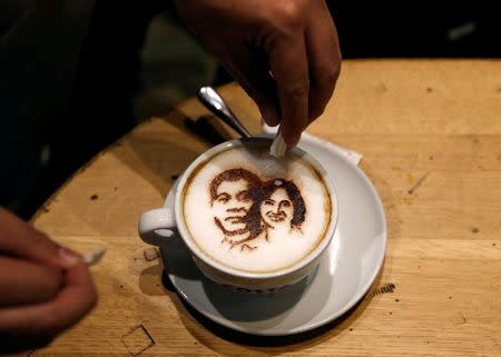 A customer adds sugar to a cup of cappucino coffee with images of incoming President-elect Rodrigo Duterte and Vice-President-elect Leni Robredo at a Costa Coffee shop, a day before Duterte and Robredo assume office, in Taguig city, Metro Manila, Philippines June 29, 2016. REUTERS/Erik De Castro