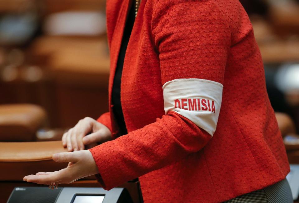 An opposition lawmaker wears an armband that reads "Resignation" before Romania's President Klaus Iohannis speech at the parliament in Bucharest, Romania, Tuesday, Feb. 7, 2017. Romania's president told lawmakers Tuesday the country is in a "fully-fledged" political crisis, after hundreds of thousands demonstrated against a government measure that would weaken the country's anti-corruption drive. (AP Photo/Vadim Ghirda)