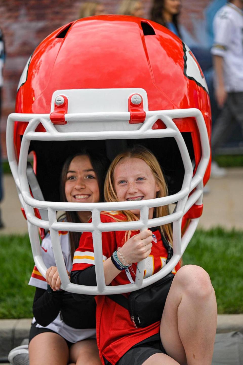 Piper Thomson, 11, left, and Lily Gamet,12, both of Liberty pose for a photo in an oversized helmet at the NFL Draft Experience Thursday, April 27, 2023, at the National WWI Museum and Memorial in Kansas City.