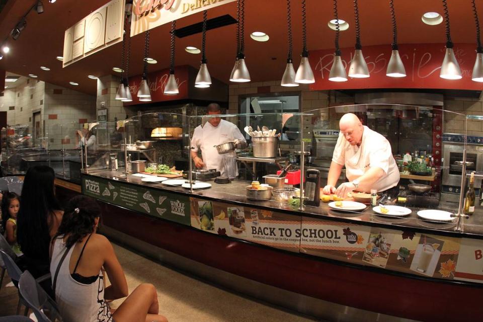 From left, Chefs Timon Balloo and Michael Jacobs cook seafood dishes at the Whole Foods Market in Coral Gables in 2011. Miami Herald File