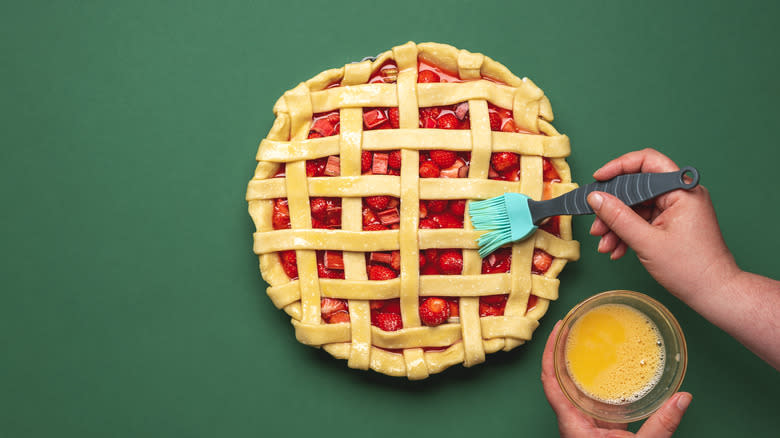 applying egg wash to pie