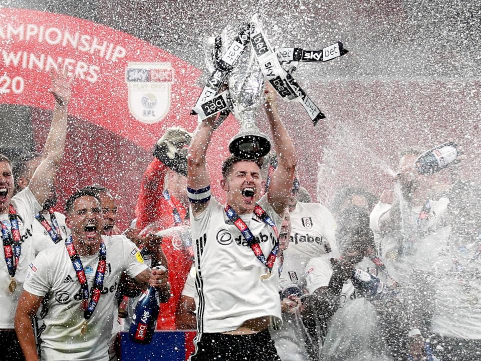 Fulham's Tom Cairney lifts the trophy as he celebrates promotion: Action Images via Reuters