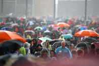 LONDON, ENGLAND - JULY 29: Members of the public shelter from the rain at the Olympic Park on Day 2 of the London 2012 Olympic Games on July 29, 2012 in London, England. (Photo by Jeff J Mitchell/Getty Images)