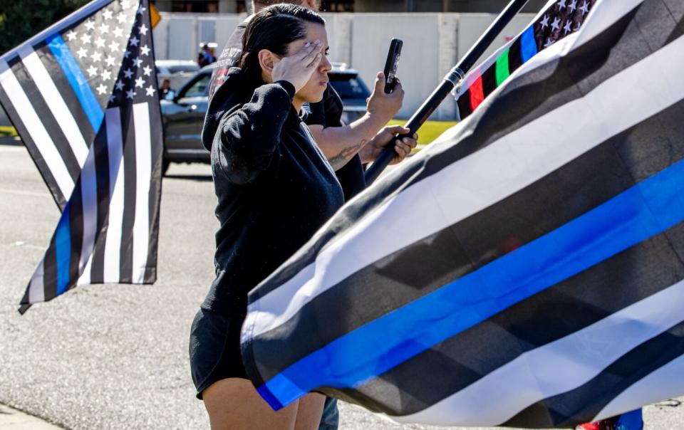 Ancelin Armijo salutes as the funeral procession for fallen Riverside County Sheriff's Deputy Darnell Calhoun.