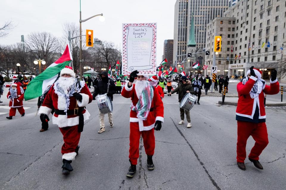 Pro-Palestinian protesters dressed as Santa during a demonstration in Ottawa on Dec. 23, 2023.