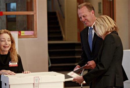 San Diego Republican mayoral candidate Kevin Faulconer (C) casts his vote with his wife Katherine (R) in San Diego, California February 11, 2014. REUTERS/Sandy Huffaker