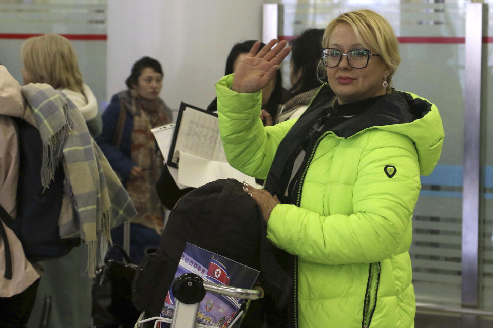 A tourist waves as a group of Russian tourists, likely the first foreign travelers from any country to enter North Korea since the pandemic arrive at the Pyongyang International Airport in Pyongyang, North Korea, Friday, Feb. 9, 2024. (AP Photo/Cha Song Ho)