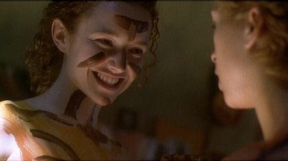 Actor Karyn Dwyer smiles. She has chocolate smudged along her face and her body.