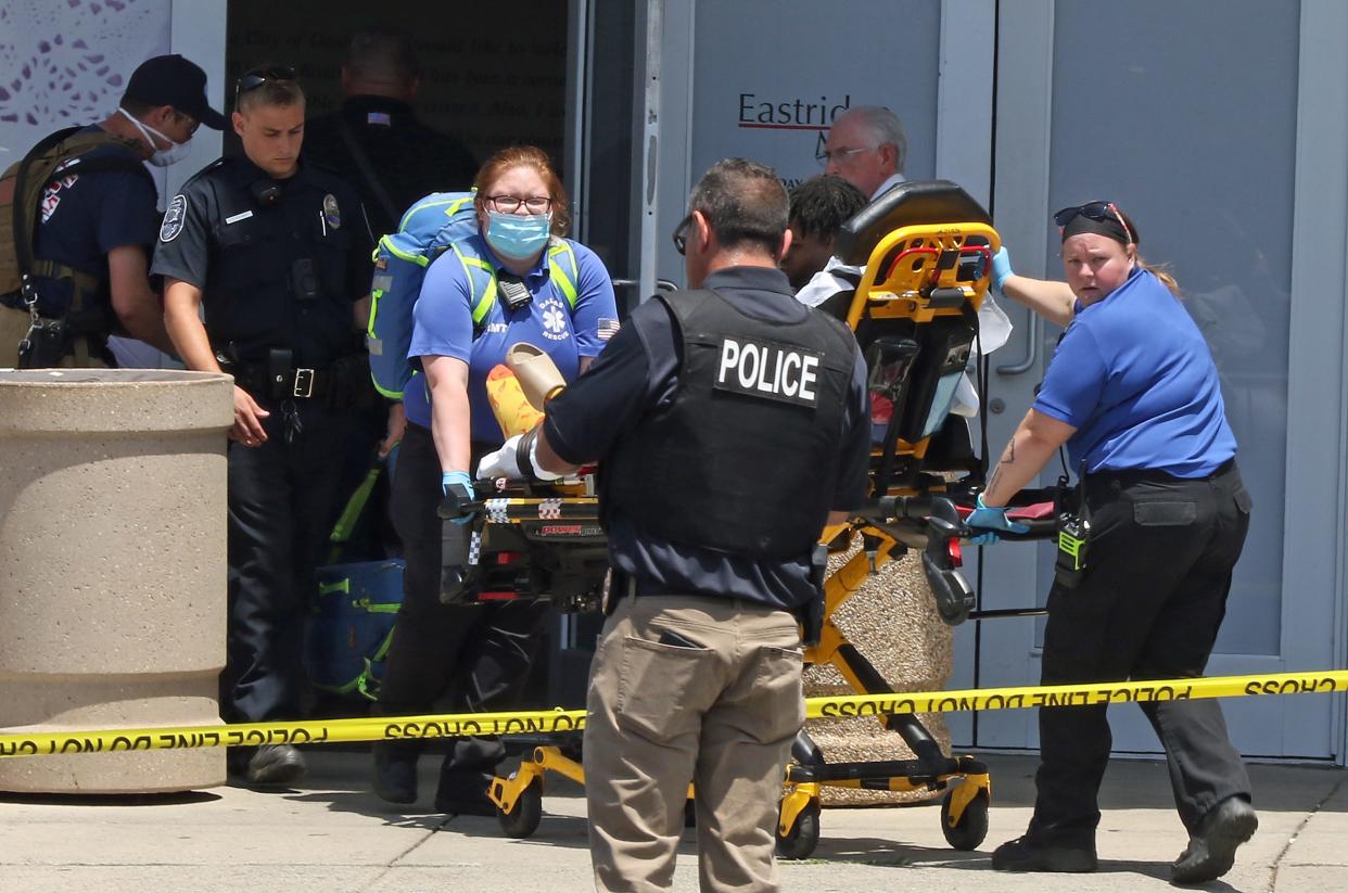 A victim is taken by paramedics to a waiting ambulance after a shooting at the Eastridge Mall Friday afternoon, June 10, 2022.