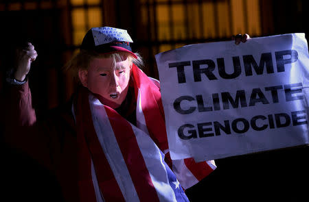 A man wearing a mask depicting U.S. President-Elect Donald Trump protests during a demonstration against climate change outside of the U.S. Embassy in London, Britain on November 18, 2016. REUTERS/Hannah McKay/File Photo