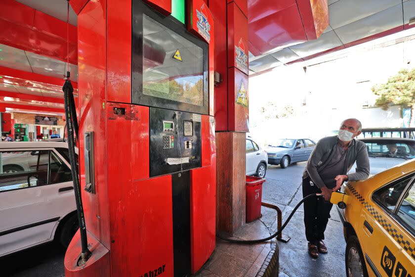 A man fills his car with petrol at a gas station in the Iranian capital Tehran, October 27, 2021.