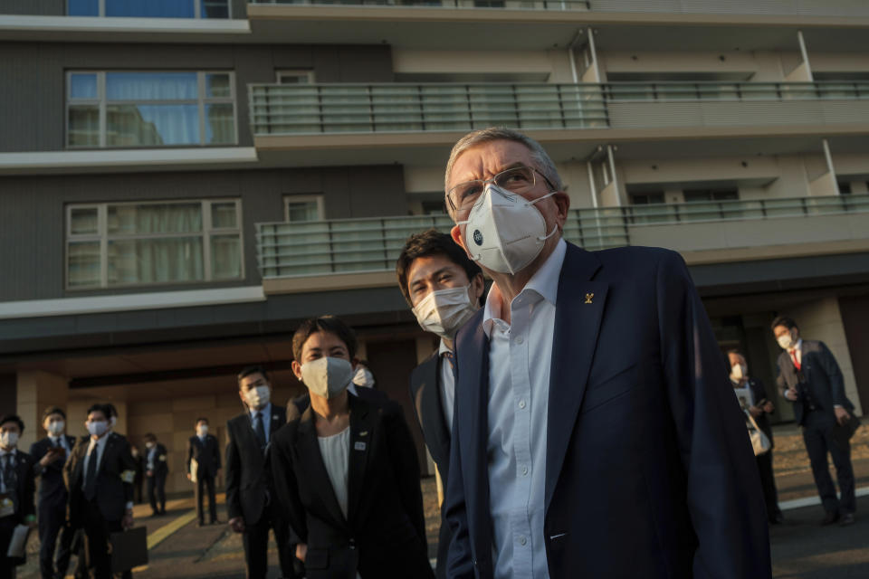 IOC President Thomas Bach wearing a protective mask visits the Olympic and Paralympic Village in Tokyo Tuesday, Nov. 17, 2020. Bach said during this week's trip to Tokyo that he is “encouraging” all Olympic “participants” and fans to be vaccinated - if one becomes available - if they are going to attend next year's Tokyo Olympics. (Nicolas Datiche/Pool Photo via AP)