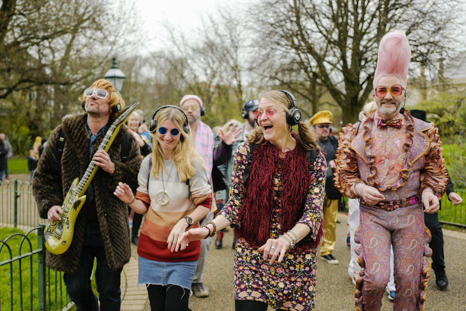 People dressed in costumes take part in a silent disco event outside the Brighton Dome, in Brighton, England, Saturday, April 6, 2024. Fans are celebrating 50 years since ABBA won its first big battle with “Waterloo.” A half century ago on Saturday, April 6, the Swedish quartet triumphed at the 1974 Eurovision Song Contest with the peppy love song. (AP Photo/Alberto Pezzali)