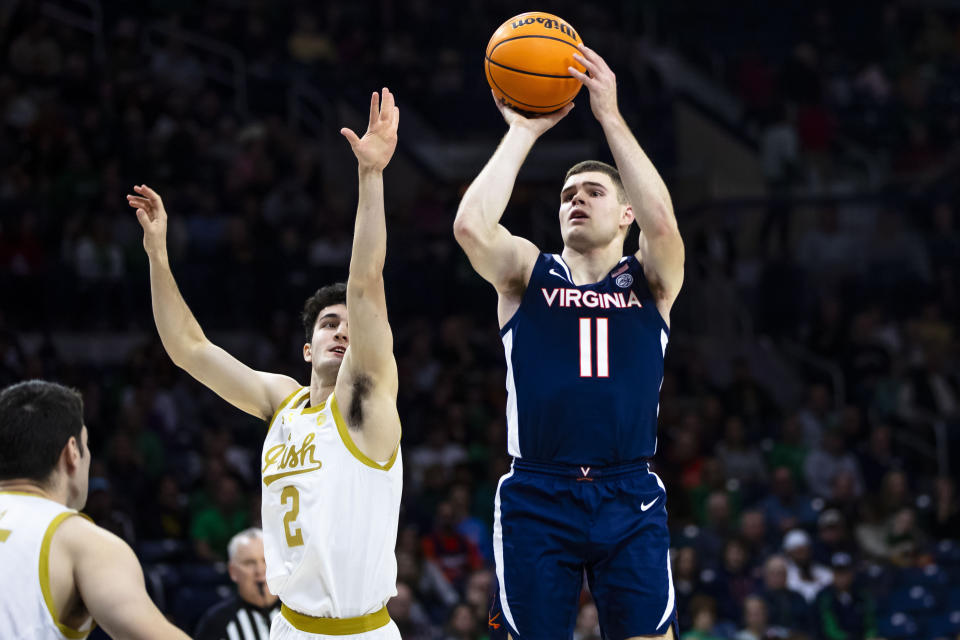 Virginia's Isaac McKneely (11) shoots as Notre Dame's Logan Imes (2) defends during the first half of an NCAA college basketball game on Saturday, Dec. 30, 2023, in South Bend, Ind. (AP Photo/Michael Caterina)