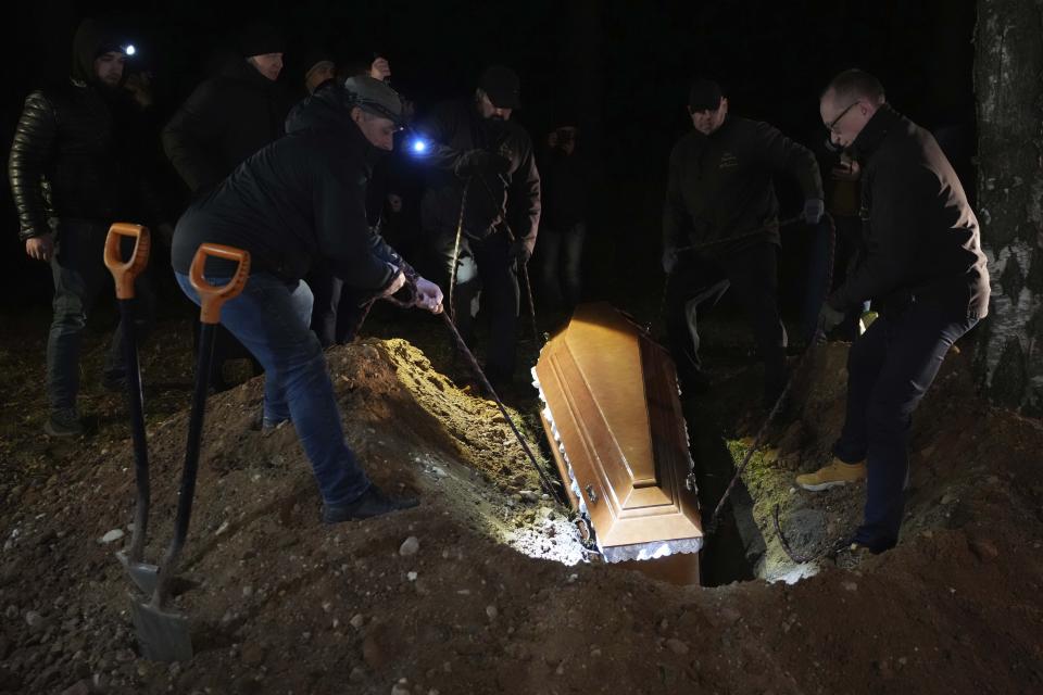 People of a Muslim congregation community lower the coffin of the young Syrian man, Ahmed al-Hassan in Bohoniki near Sokolka, Poland, Monday, Nov. 15, 2021. The 19-year-old man died in late October in a river in this freezing, forested buffer zone. The authoritarian Belarusian regime in Minsk has for months been orchestrating a flow of migrants across its border into the three European Union nations, which form the eastern flank of both the 27-nation EU and NATO. In response, the three have been reinforcing their borders. (AP Photo/Matthias Schrader)