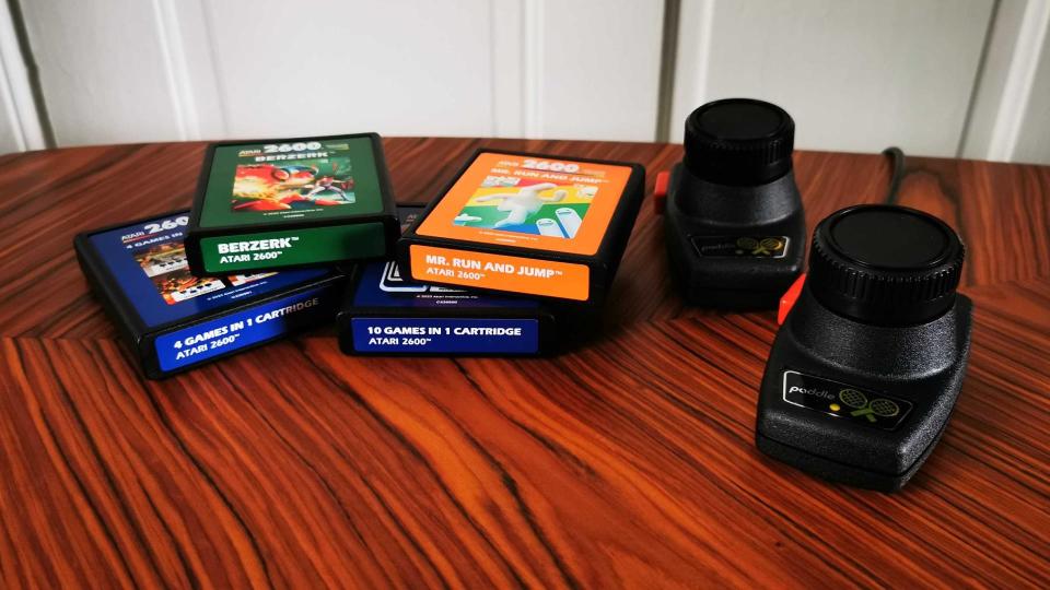 Atari 2600 cartridges next to paddle controllers