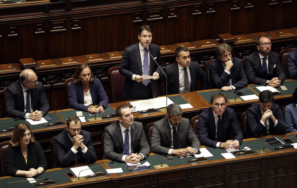 Italian Premier Giuseppe Conte, standing at center, sits with his cabinet ministers as he addresses parliament ahead of confidence vote later at the Lower Chamber in Rome, Monday, Sept. 9, 2019. Conte is pitching for support in Parliament for his new left-leaning coalition ahead of crucial confidence votes. (AP Photo/Andrew Medichini)