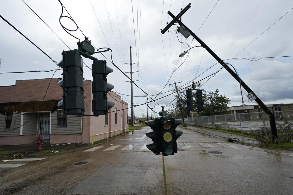 Traffic signals dangle close to the roadway from broken utility poles in Lake Charles, La., in the aftermath of Hurricane Laura, Sunday, Aug. 30, 2020. (AP Photo/Gerald Herbert)