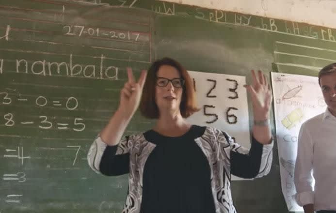 Former Prime Minister of Australia, Julia Gillard, is seen teaching children with a chalkboard. Source: Global Citizen