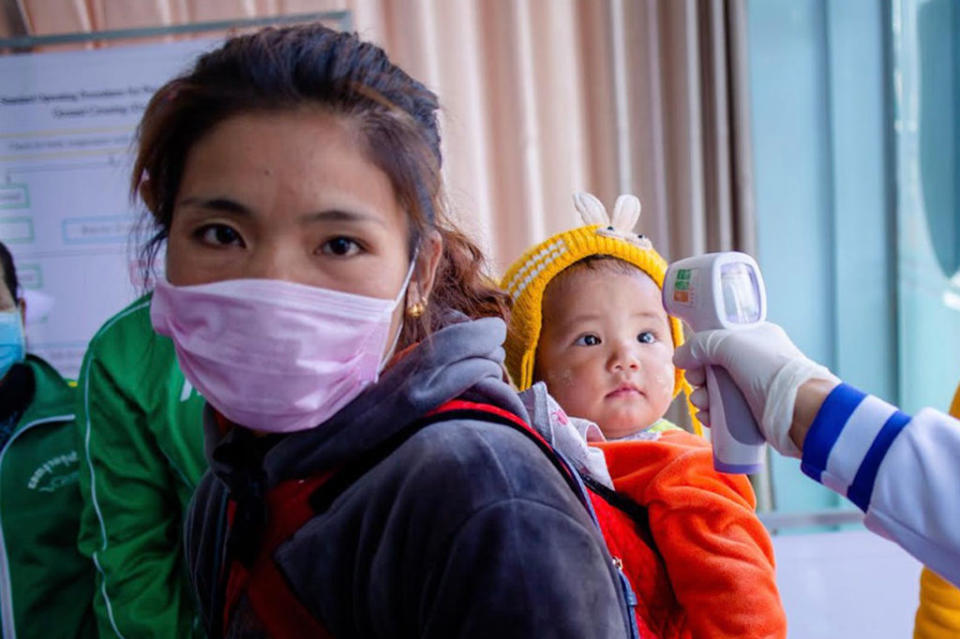 A Myanmar health officer checks the temperature of a child entering the Myanmar-China border crossing in Muse, Shan State on Jan. 31, 2020. | PHYO MAUNG MAUNG—AFP/Getty Images