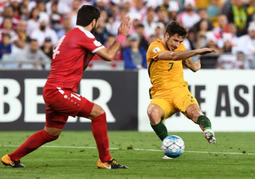 Syria's Tamer Hag Mohamad (L) blocks a shot by Mathew Leckie of Australia during a 2018 World Cup qualifier in Sydney on October 10, 2017