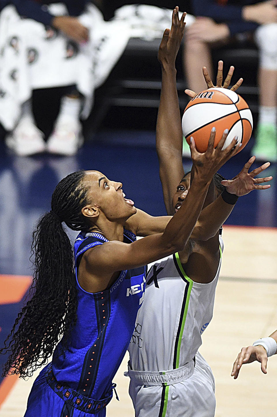 Connecticut Sun's DeWanna Bonner (24) puts up a basket from under Minnesota Lynx's Diamond Miller (1) during a WNBA basketball game, Sunday, Sept. 17, 2023, at Mohegan Sun Arena in Uncasville, Conn. (Sarah Gordon/The Day via AP)