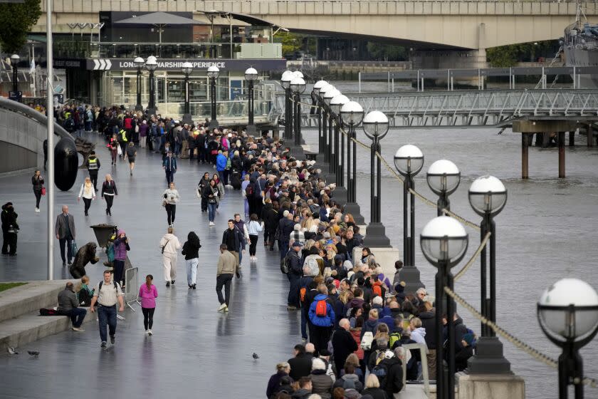 People queue near London Bridge to pay their respects to late Queen Elizabeth II who's lying in state at Westminster Hall in London, Friday, Sept. 16, 2022. The Queen will lie in state in Westminster Hall for four full days before her funeral on Monday Sept. 19. (AP Photo/Christophe Ena)