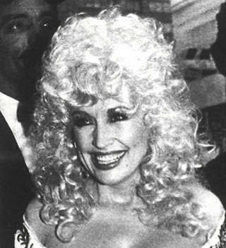 La chanteuse américaine de pop et de country Dolly Parton photographiée en 1984, en plein âge d’or de la permanente.. PHOTO COLIN MCPHERSON/AFP