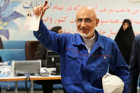 Mostafa Mirsalim, Iranian former minister of culture, holds his document as he registers his candidacy for presidential elections at the Interior Ministry in central Tehran, Iran, April 11, 2017. Tasnim News Agency/Handout via REUTERS