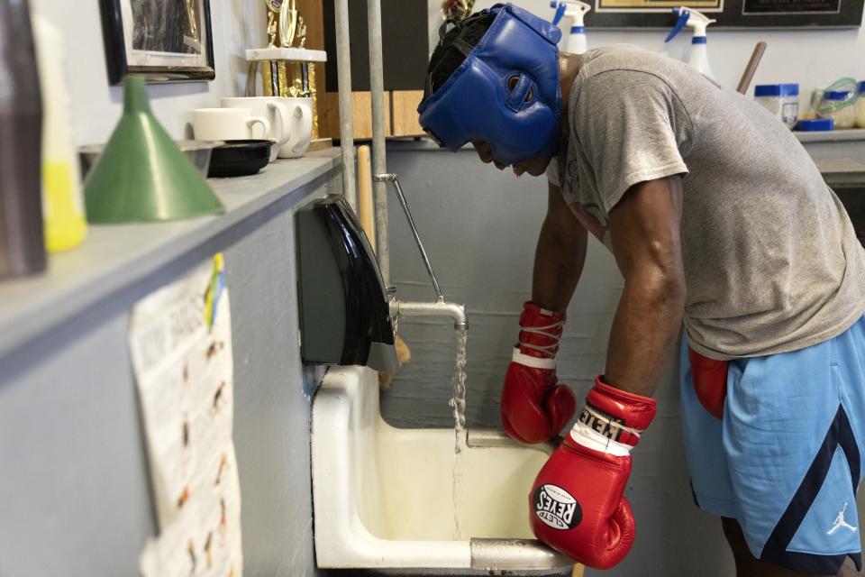 Theon Davis, 21, takes a rest as he spars with another boxer during training for his 176-pound Chicago Golden Gloves tournament boxing match at Garfield Park Boxing Wednesday, March 29, 2023, in Chicago. He spends hours sparring and hitting the bags and lifting weights and running laps around a basketball court at a recreation center in Garfield Park, the neighborhood on Chicago’s West Side where he grew up. (AP Photo/Erin Hooley)