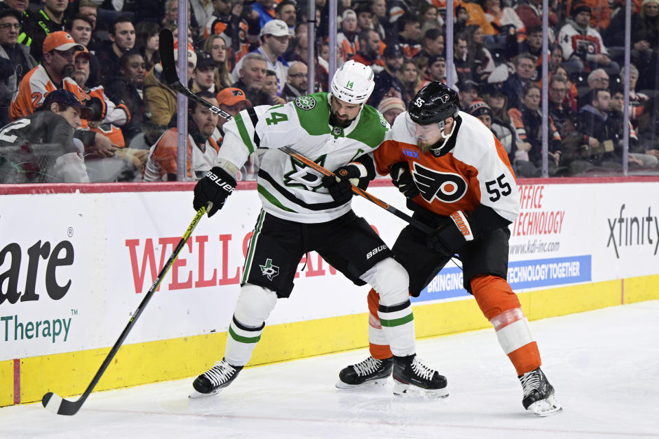 Dallas Stars' Jamie Benn, left, and Philadelphia Flyers' Rasmus Ristolainen battle for the puck during the first period of an NHL hockey game Thursday, Jan. 18, 2024, in Philadelphia. (AP Photo/Derik Hamilton)