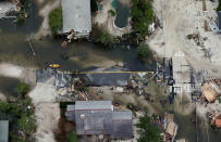 The remains of a road are mired in debris and water from Superstorm Sandy on October 31, 2012 in Mantoloking, New Jersey. At least 50 people were reportedly killed in the U.S. by Sandy with New Jersey suffering massive damage and power outages. (Photo by Mario Tama/Getty Images)