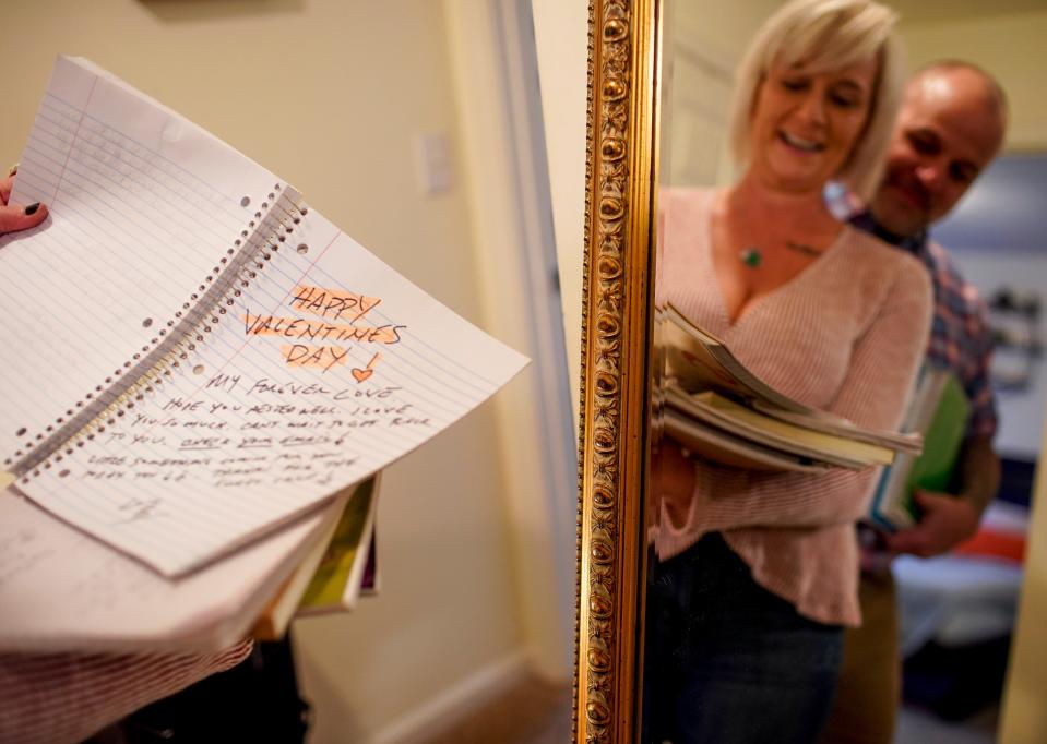 Susan Fenske sifts through notebooks she and her husband, Bret, filled with love notes at their apartment in Clarksville, Tenn., on Feb. 4.