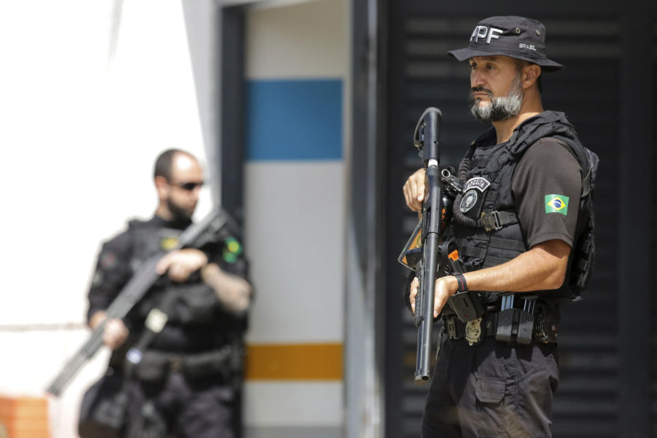 Federal Police stand guard as former Brazilian President Jair Bolsonaro leaves after giving testimony over the Jan. 8 attacks in Brasilia, Brazil, Wednesday, April 26, 2023. Thousands of Bolsonaro supporters trashed the presidential palace, the Supreme Court and Congress one week into President Luiz Inácio Lula da Silva's third term in office. (AP Photo/Eraldo Peres)