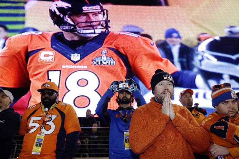 Denver Broncos fans react during the first half of the NFL Super Bowl XLVIII football game against the Seattle Seahawks as Peyton Manning is shown on the screen behind them Sunday, Feb. 2, 2014, in East Rutherford, N.J. (AP Photo/Seth Wenig)