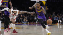 Los Angeles Lakers guard D'Angelo Russell (1) dribbles past Toronto Raptors guard Gary Trent Jr. during the first half of an NBA basketball game Friday, March 10, 2023, in Los Angeles. (AP Photo/Marcio Jose Sanchez)