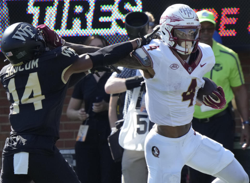 FILE - Florida State wide receiver Keon Coleman (4) runs past Wake Forest defensive back Evan Slocum (14) for a touchdown during the first half of an NCAA college football game in Winston-Salem, N.C., Oct. 28, 2023. Coleman has been selected by The Associated Press as the newcomer of the year for the Atlantic Coast Conference. (AP Photo/Chuck Burton, File)