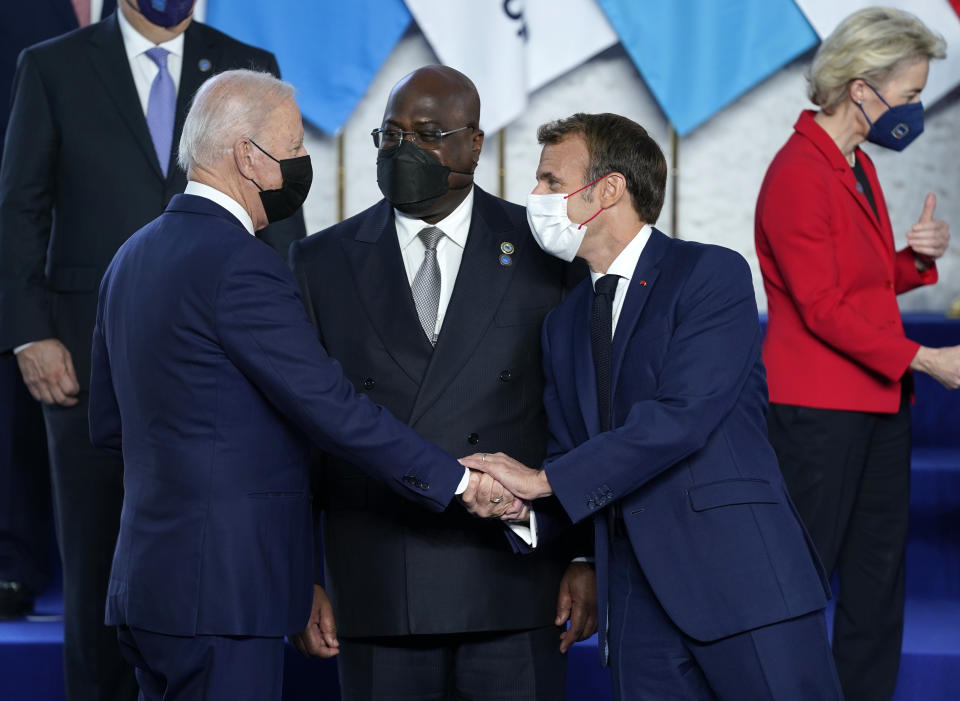 U.S. President Joe Biden, left, greets French President Emmanuel Macron, second right, during a group photo at the G20 summit in Rome, Saturday, Oct. 30, 2021. The two-day Group of 20 summit is the first in-person gathering of leaders of the world's biggest economies since the COVID-19 pandemic started. (AP Photo/Evan Vucci, Pool)