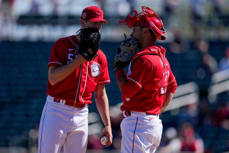 Cincinnati Reds relief pitcher Brandon Williamson (55) meets with catcher Luke Maile (22) at the mound in the first inning of the MLB Cactus League spring training game between the Cincinnati Reds and the Cleveland Guardians at Goodyear Ballpark in Goodyear, Ariz., on Saturday, Feb. 25, 2023.