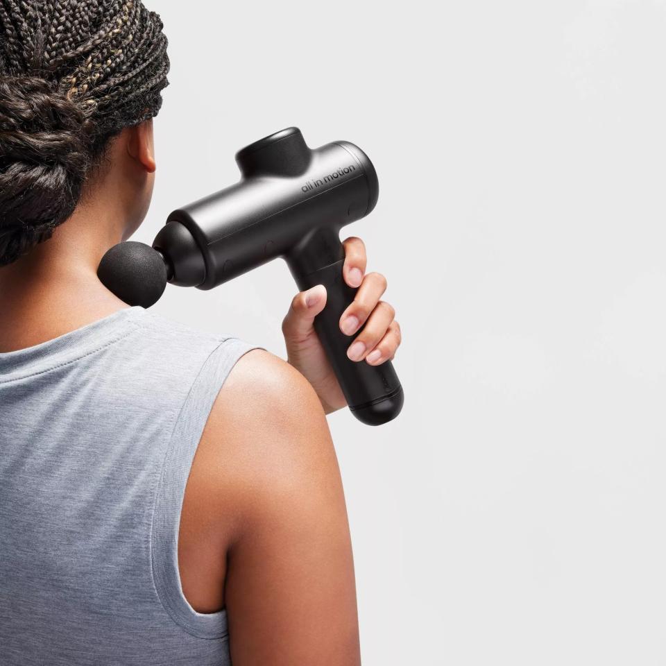 A person using the massager on their shoulder