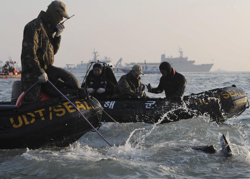 Divers look for people believed to have been trapped in the sunken ferry Sewol in the water off the southern coast near Jindo, south of Seoul, South Korea, Wednesday, April 23, 2014. The grim work of recovering bodies from the submerged South Korea ferry proceeded rapidly Wednesday, with the official death toll reaching over 140, though a government official said divers must now rip through cabin walls to retrieve more victims. (AP Photo/Yonhap) KOREA OUT