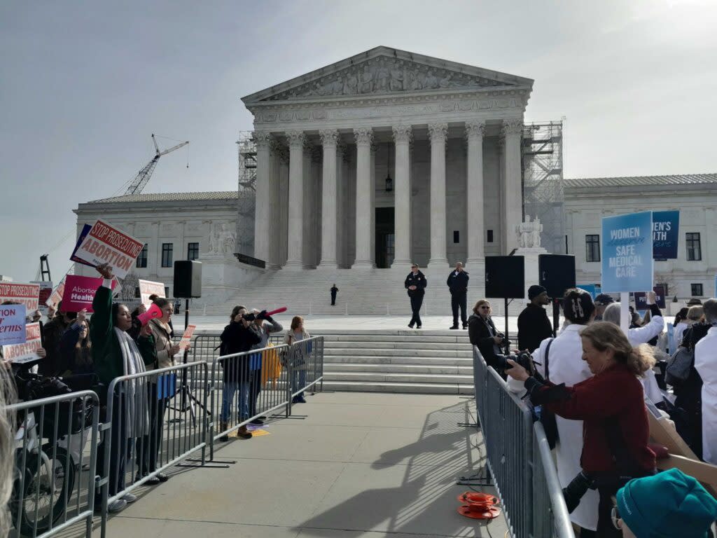 Protestors behind metal barriers at the U.S. Supreme Court