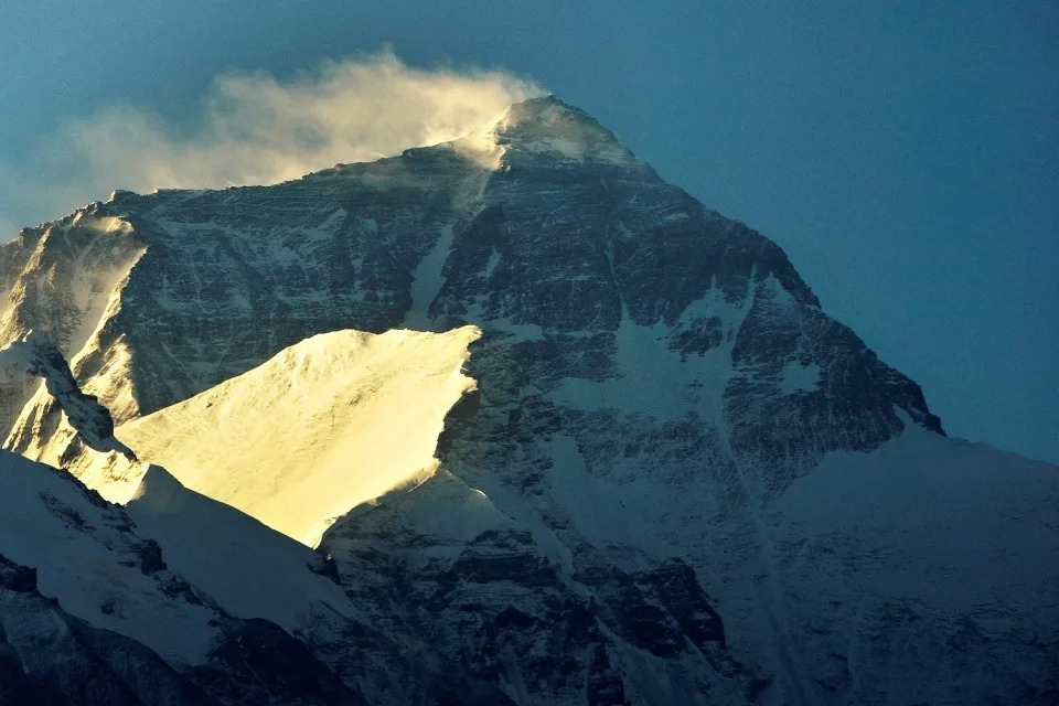 Wind blows snow off the summit at sunrise of the world's highest mountain Mount Everest, also known as Qomolangma, in the Tibet Autonomous Region (David Gray / Reuters file)