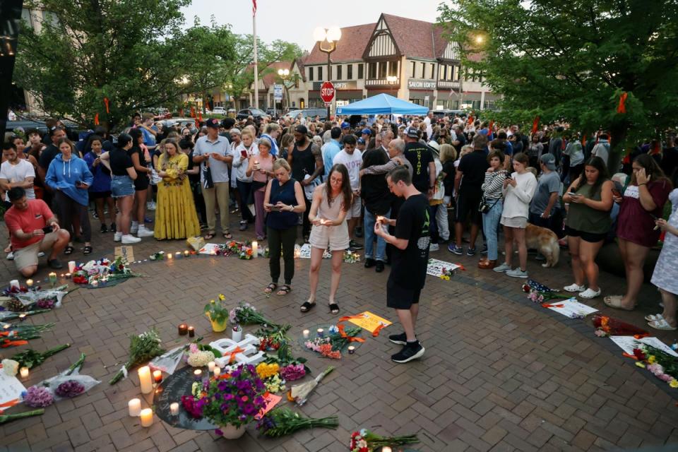 Dozens of mourners gather for a vigil near Central Avenue and St Johns Avenue in downtown Highland Park (AP)