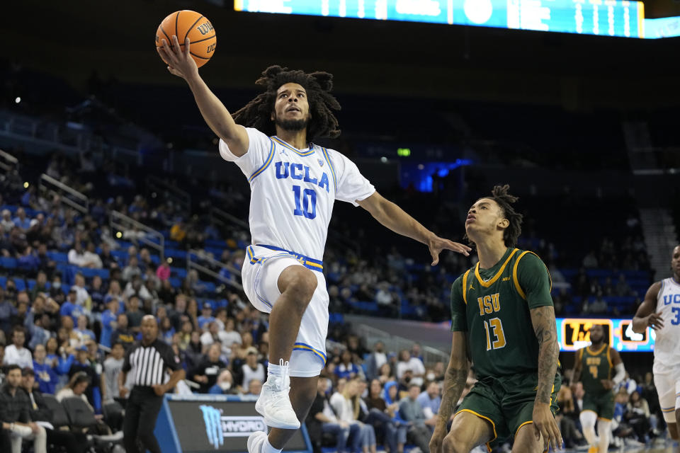 UCLA guard Tyger Campbell, left, shoots as Norfolk State guard Daryl Anderson defends during the second half of an NCAA college basketball game Monday, Nov. 14, 2022, in Los Angeles. UCLA won 86-56. (AP Photo/Mark J. Terrill)