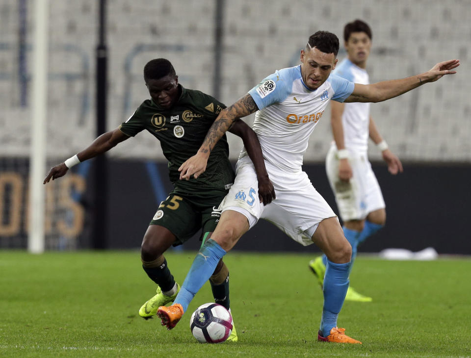 Reims'Moussa Doumbia, left, challenges for the ball with Marseille's Lucas Ocampos, during the League One soccer match between Marseille and Reims at the Velodrome stadium, in Marseille, southern France, Sunday, Dec. 2, 2018. (AP Photo/Claude Paris)