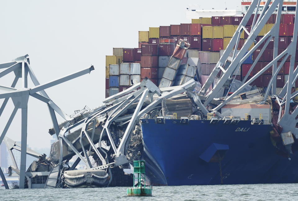 A cargo ship is stuck under the part of the structure of the Francis Scott Key Bridge after the ship hit the bridge Tuesday March 26, 2024, in Baltimore, Md. (AP Photo/Steve Helber)
