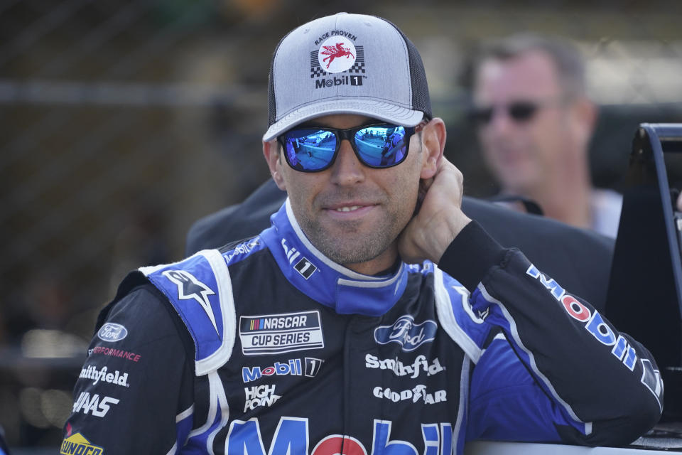 Aric Almirola waits by his car before qualifications for the NASCAR Series auto race at Indianapolis Motor Speedway, Sunday, Aug. 15, 2021, in Indianapolis. (AP Photo/Darron Cummings)