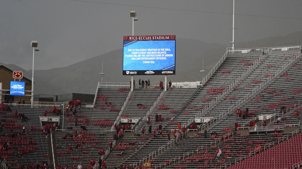 Fans clears the stands at Rice-Eccles Stadium during a delay due to inclement weather during the first half of an NCAA college football game between Weber State and Utah on Thursday, Sept. 2, 2021, in Salt Lake City. (AP Photo/Rick Bowmer)